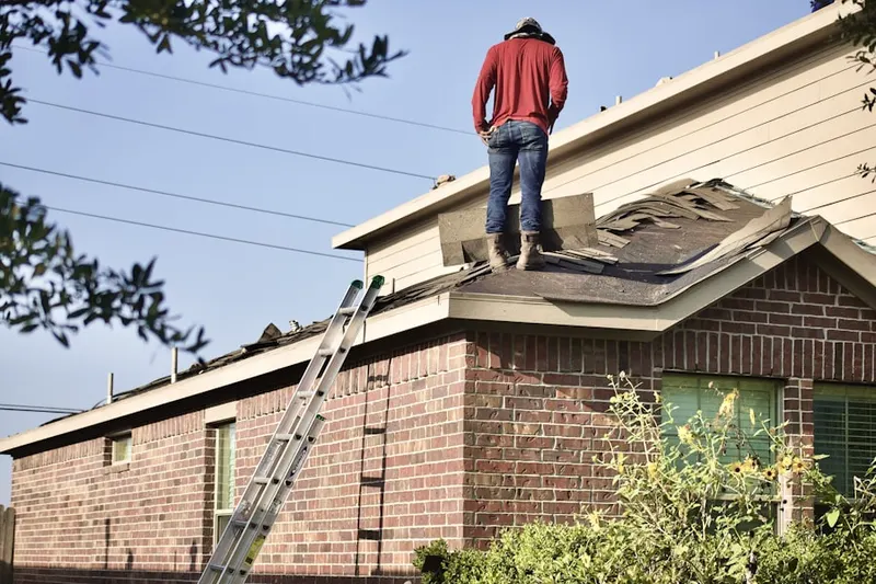 Professional roofer working on a residential roof in Atco